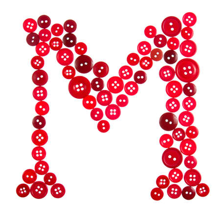The letter M made of photographed buttons, isolated on a white backgroundの写真素材