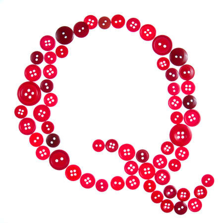 The letter Q made of photographed buttons, isolated on a white backgroundの写真素材