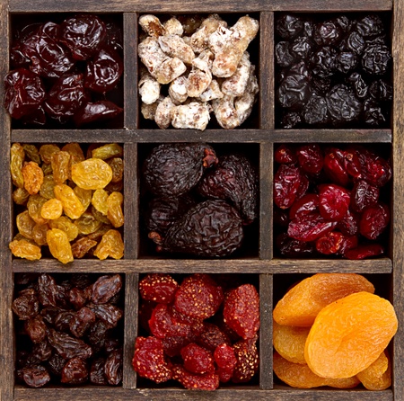Assorted dried fruit arranged in a printers boxの写真素材