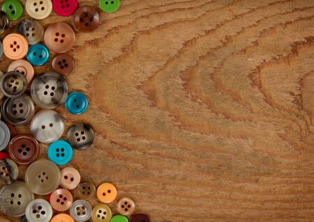 Assorted vintage sewing buttons on a wooded background, room for copy spaceの写真素材