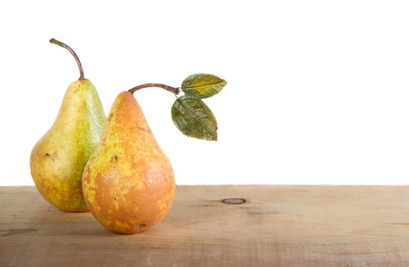 Two pears on a wooden plank with a white isolated backgroundの写真素材