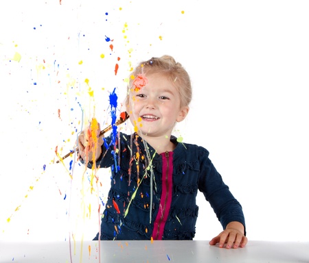 Little girl painting paint splatters on a window, isolated on whiteの写真素材