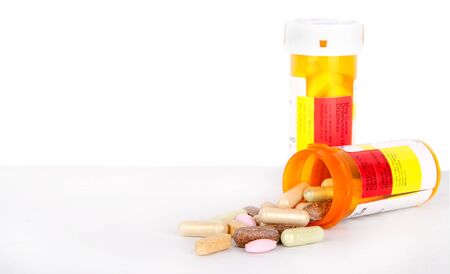 Pills spilling out of a perscription bottle, isolated backgroundの写真素材