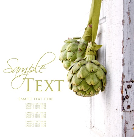 two artichokes hanging from a vintage door, area for copy spaceの写真素材