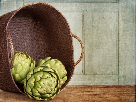 artichokes spilling out of a basket, with a grunge backgroundの写真素材