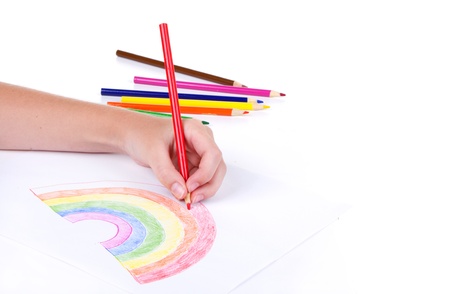 Close-up of girl drawing a rainbow with colored pencilsの写真素材