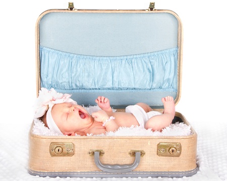 Newborn baby yawning in a vintage suitcaseの写真素材