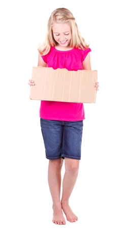 Girl holding a blank cardboard sign, looking down, isolated on whiteの写真素材