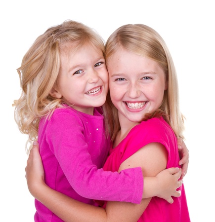 sisters hugging isolated on whiteの写真素材