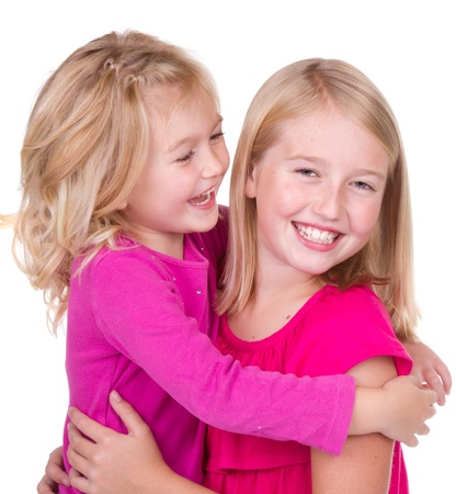 sisters hugging and looking at each other isolated on whiteの写真素材