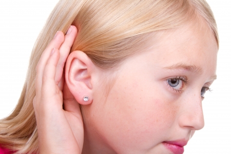 Closeup of teens ear, hand to ear listening isolated on whiteの写真素材