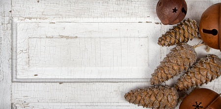 Chirstmas ornaments pinecones and rusty bells on antique cracked wood panelの写真素材