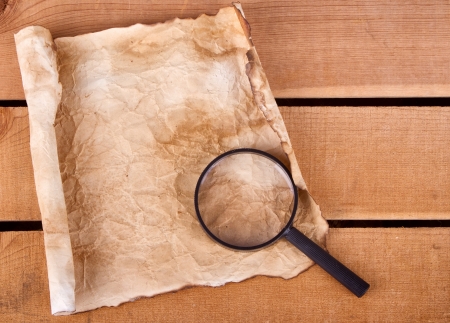Blan map with magnifying glass on a plankの写真素材