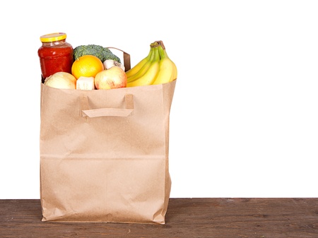 Food contents of a brown paper shopping bag on whiteの写真素材