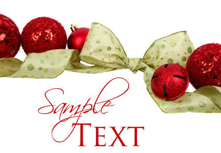 Green Christmas ribbon and red ornaments isolated on white.の写真素材