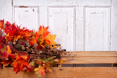 Autumn still life with acorns and leaves with wooden panel for backgroundの写真素材