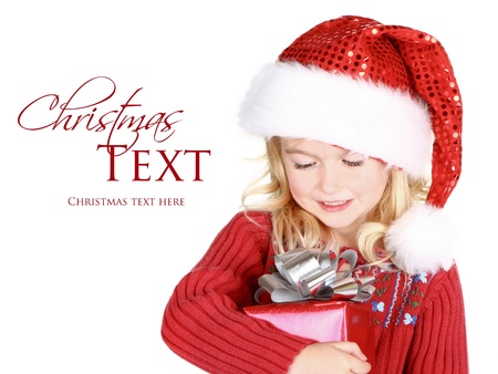 Child holding present wearin santa hat isolated on whiteの写真素材