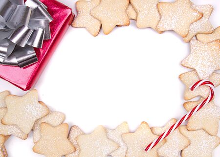 Christmas cookies framed on white with present and candy caneの写真素材