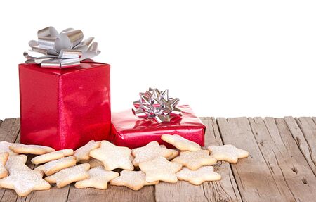 Presents and cookies on a rustic wooden plank, isolated white backgroundの写真素材
