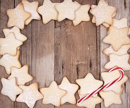 Star Christmas cookies and candy canes on wooden backgroundの写真素材