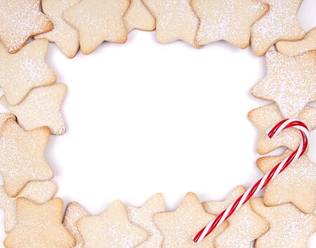 Star Christmas cookies and candy canes framed on white backgroundの写真素材