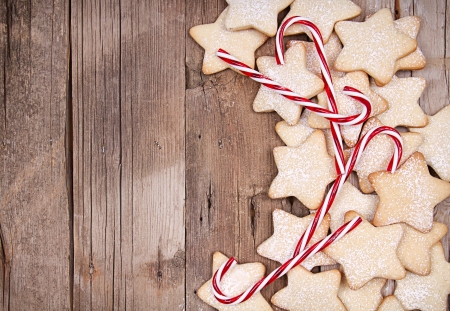 Star Christmas cookies and candy canes framed on wooden backgroundの写真素材