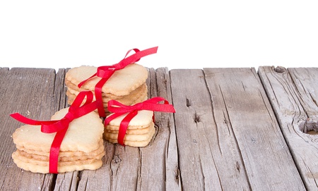 Heart shaped sugar cookie tied with red ribbon on wooden backgroundの写真素材