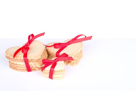 Heart shaped sugar cookie tied with red ribbon on white backgroundの写真素材