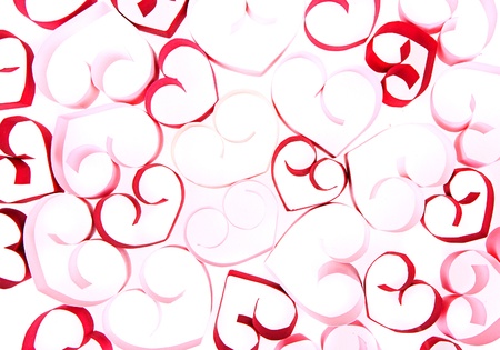 Paper shaped like a heart in shades of pink and red on a white backgroundの写真素材