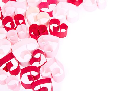 Paper shaped like a heart in shades of pink and red on a white backgroundの写真素材