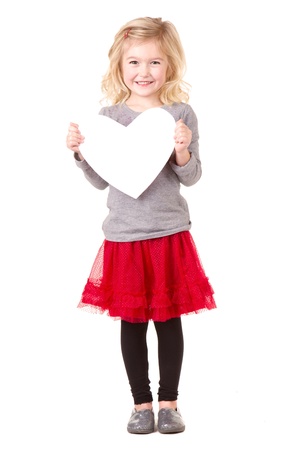 Little girl holding white heart, full lenth photo isolated on whiteの写真素材