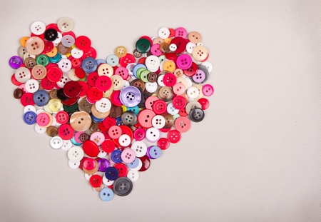 Multi colored buttons in shape of heart on fabric backgroundの写真素材