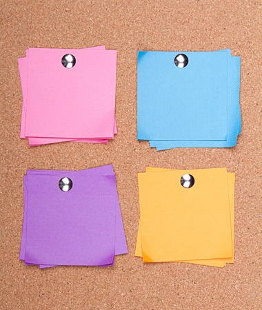 multi colored sticky notes with push pins on a bulletin boardの写真素材