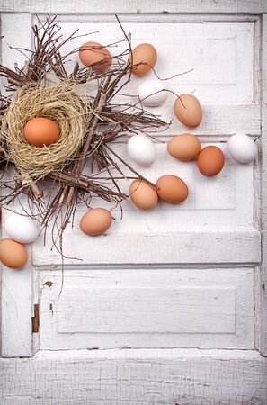 Brown eggs in a nest on a cracked antique wooden panelの写真素材
