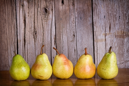 Pears lined up in a row on a rustic wooden backgroundの写真素材