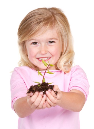 Young girl or child holding a  plant while smiling, isolated on white の写真素材