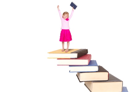 Child or girl on top of staircase of books cheering, isolated on whiteの写真素材