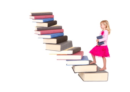 child or girl climbing a staircase of books, isolated on whiteの写真素材