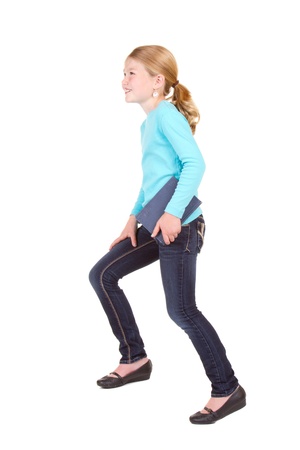 child or girl holding book stepping up isolated on whiteの写真素材