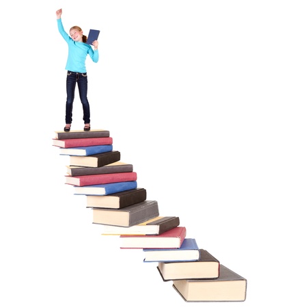 Child or girl on top of staircase of books cheering, isolated on whiteの写真素材