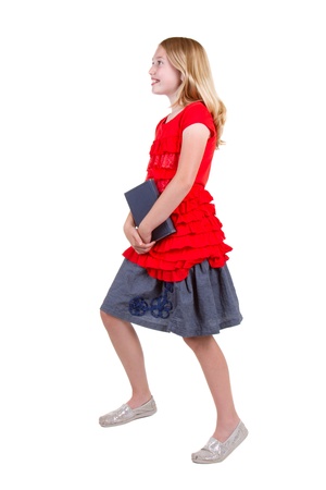 teen holding book walking up stairs isolated on whiteの写真素材