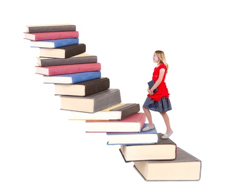 teen climbing a staircase of books, isolated on whiteの写真素材