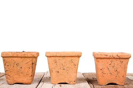 Terracotta or clay gardening pots on a wooden plank on a white backgroundの写真素材