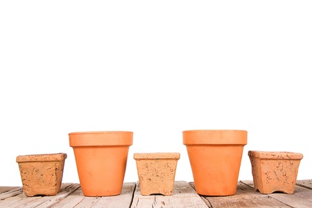 Terracotta or clay gardening pots on a wooden plank on a white backgroundの写真素材