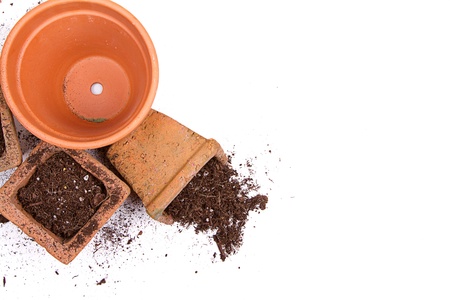 Terracotta or clay gardening pots with dirt spilling out of a pot, on a white backgroundの写真素材