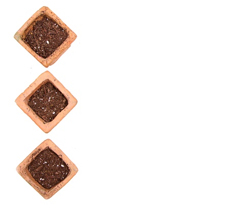 Terracotta or clay gardening pots with dirt on a white backgroundの写真素材