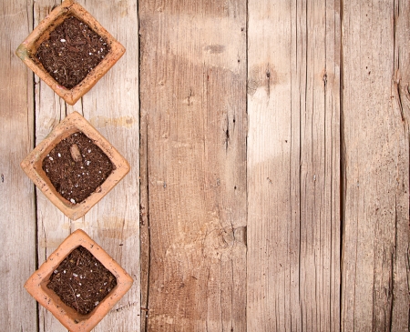 Terracotta or clay gardening pots with dirt on a wooden backgroundの写真素材