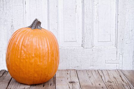 pumpkin on rustic wooden plank with a antique white backgroundの写真素材
