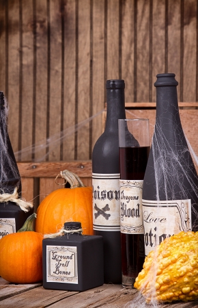 Potion bottles with pumpkins and gourds on wooden planksの写真素材