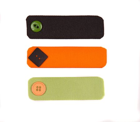 Halloween colored ribbon tags with sewing buttons isolated on whiteの写真素材